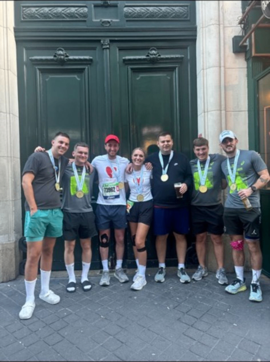 The seven Mitchy Foundation runners standing together with their medals after finishing the Paris Marathon.